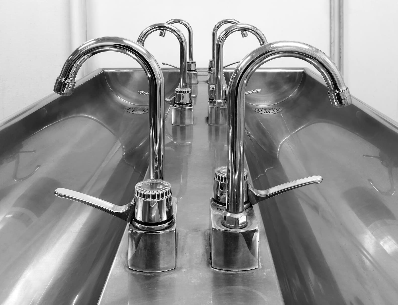 A stainless wet-area corner that wants coving, not a dirt step